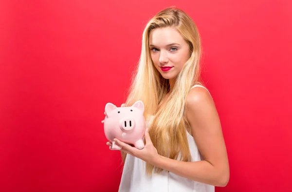 Young woman with a piggy bank — Stock Photo, Image