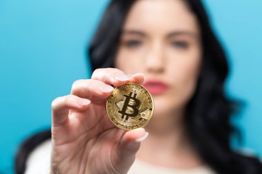 Fiziksel bir bitcoin tutan kadın