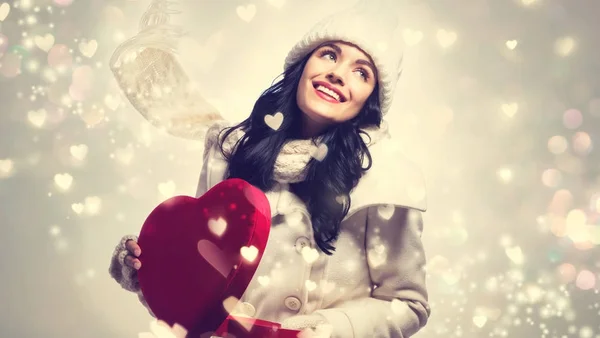Mujer joven sosteniendo una gran caja de regalo de corazón — Foto de Stock