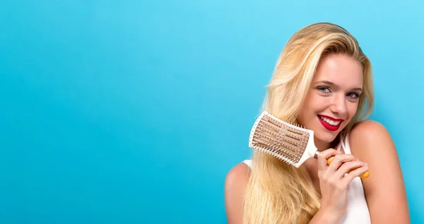 Mulher bonita segurando uma escova de cabelo — Fotografia de Stock