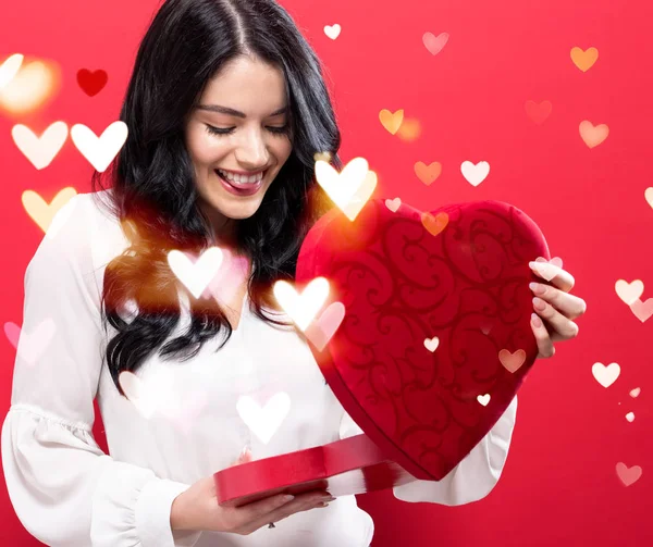 Feliz joven mujer sosteniendo una gran caja de regalo de corazón — Foto de Stock