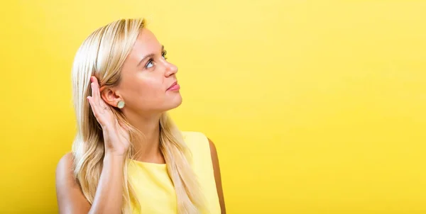 Mujer joven escuchando algo — Foto de Stock