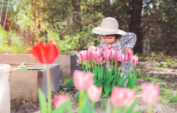 Ragazza bambino giocare con tulipani al di fuori — Foto Stock