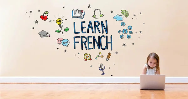 Lär dig franska texten med liten flicka använder en bärbar dator — Stockfoto