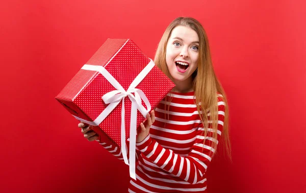 Joyeux jeune femme tenant une boîte cadeau — Photo