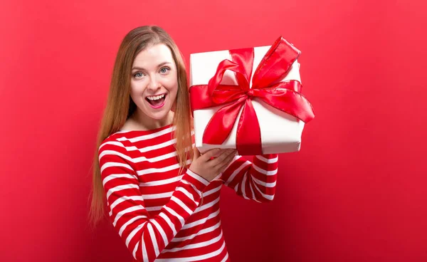 Happy young woman holding a gift box — Stock Photo, Image