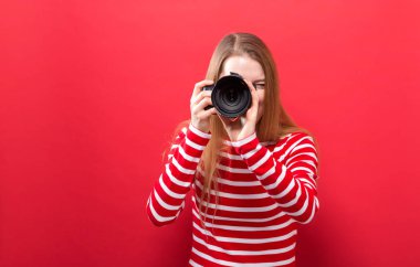 Elinde kamera olan genç bir kadın.