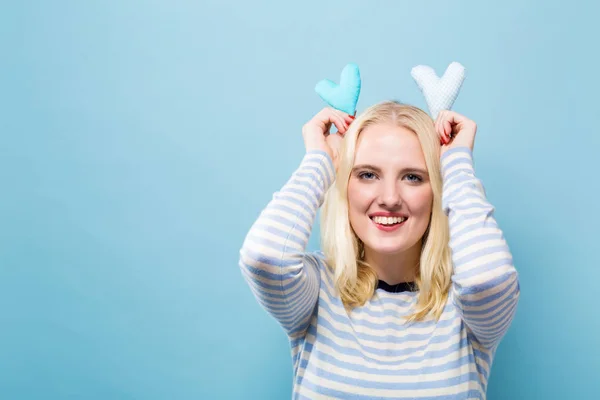 Gelukkig jonge vrouw met hart kussens — Stockfoto