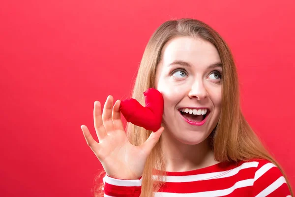 Felice giovane donna in possesso di un cuscino del cuore — Foto Stock