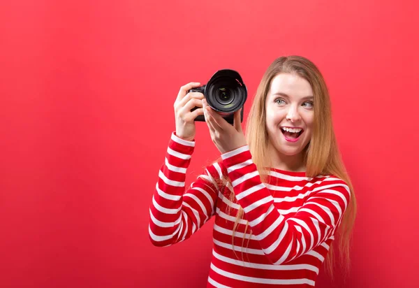 Giovane donna che tiene una macchina fotografica — Foto Stock