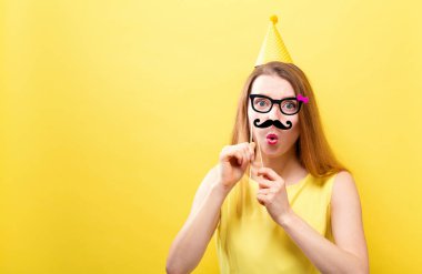 Kağıt parti sopa tutan genç kadın