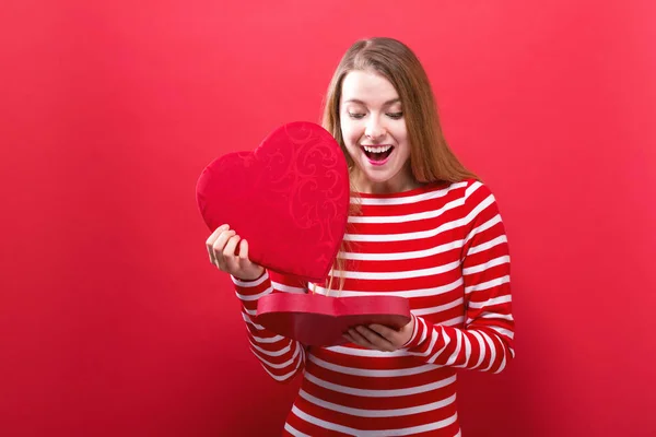 Glad ung kvinna håller en stort hjärta presentförpackning — Stockfoto
