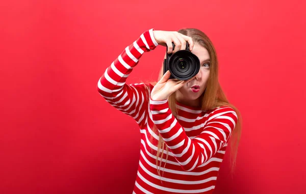 Młoda kobieta trzyma aparat fotograficzny — Zdjęcie stockowe