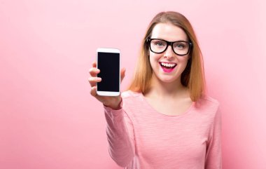 Bir cep telefonu tutan genç kadın