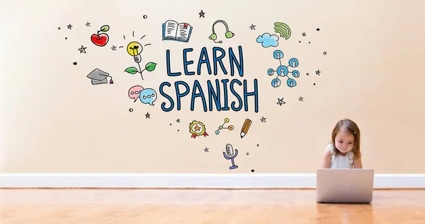 Lär dig spanska text med liten flicka använder en bärbar dator — Stockfoto