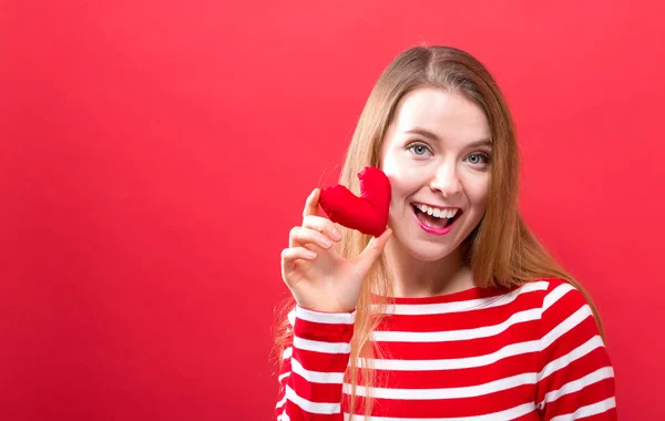 Felice giovane donna in possesso di un cuscino del cuore — Foto Stock