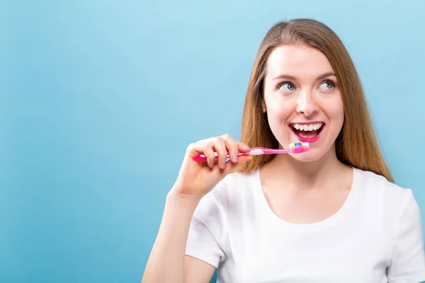 Mujer joven sosteniendo un cepillo de dientes — Foto de Stock