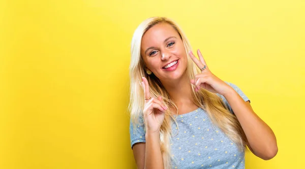 Mujer joven dando la señal de paz — Foto de Stock