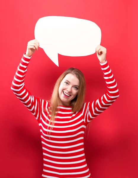 Young woman holding a speech bubble — Stock Photo, Image