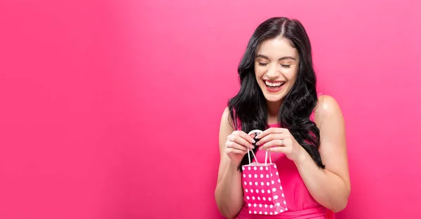 Young woman holding a tiny shopping bag — Stock Photo, Image