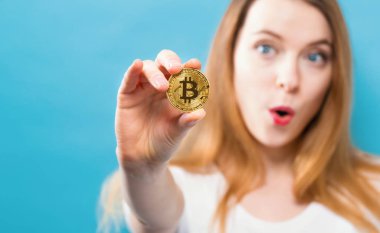 Fiziksel bir bitcoin tutan kadın