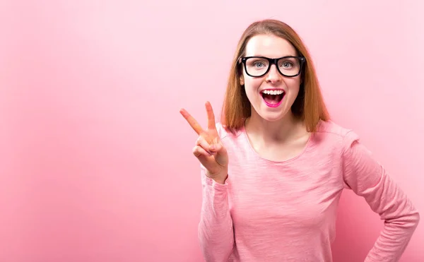 Junge Frau gibt das Friedenszeichen — Stockfoto