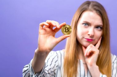 Fiziksel bir bitcoin tutan kadın