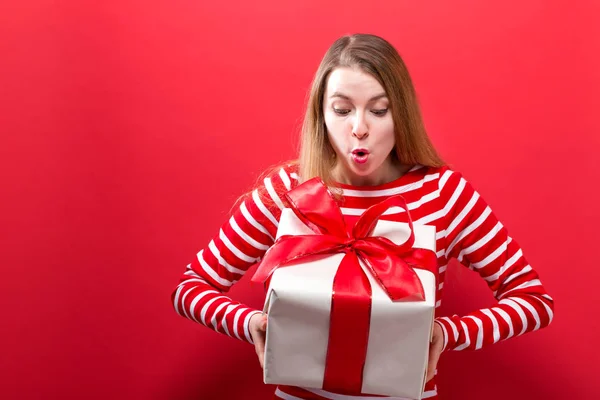 Mujer joven feliz sosteniendo una caja de regalo — Foto de Stock