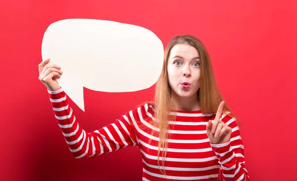 Mujer joven sosteniendo una burbuja del discurso — Foto de Stock