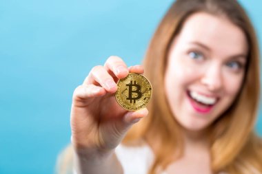 Fiziksel bir bitcoin tutan kadın