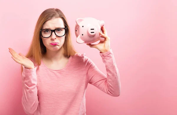 Mujer joven con una alcancía — Foto de Stock