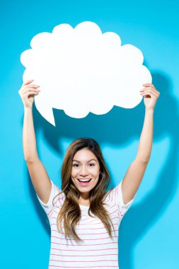 Elinde konuşma balonu tutan genç bir kadın.