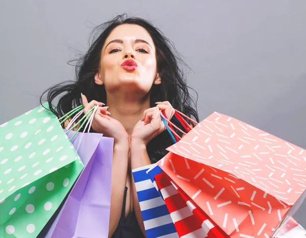 Glad ung kvinna som håller i shoppingväskor — Stockfoto
