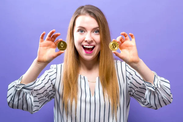 Mujer sosteniendo bitcoin físico y monedas etéreo — Foto de Stock