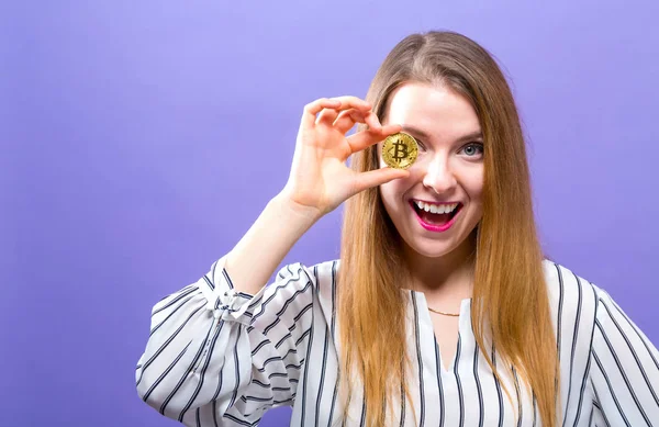 Kvinna som håller en fysisk bitcoin — Stockfoto