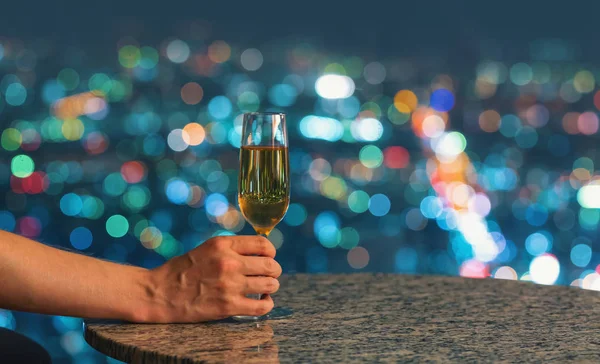 L'uomo con il vino in alto sopra la città di notte — Foto Stock