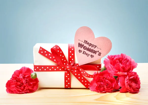 プレゼント ボックスと花を持つ女性の日メッセージ — ストック写真