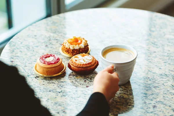 Mujer con una taza de café y pasteles — Foto de Stock