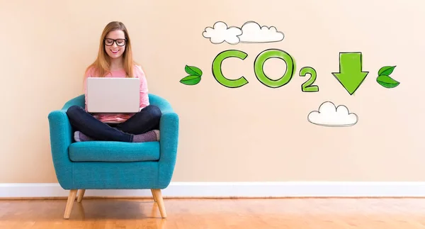 Зменшити CO2 з молодою жінкою, використовуючи її ноутбук — стокове фото