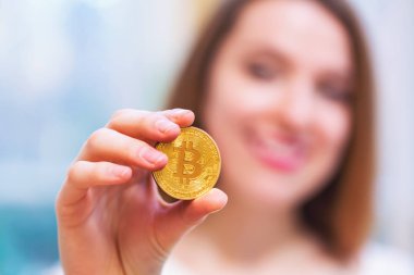 Bir fiziksel bitcoin cryptocurrency tutan kadın