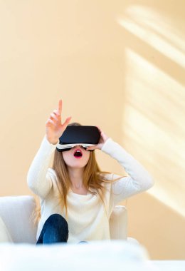 Sanal gerçeklik kulaklığı kullanan genç bir kadın.