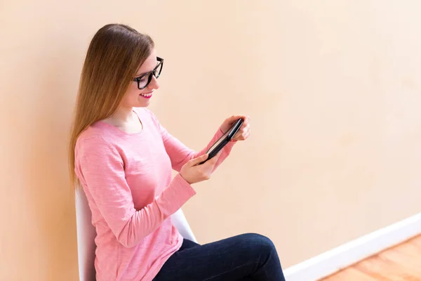 Jonge vrouw lezen met een e-reader in een grote ruimte — Stockfoto