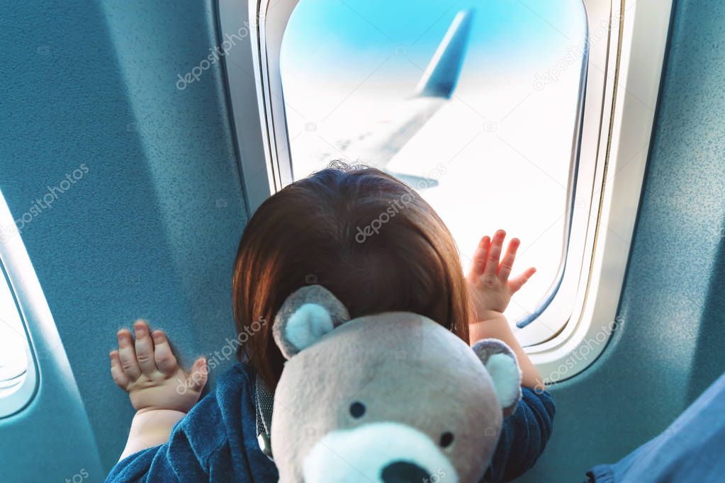 Toddler boy looking out a plane window
