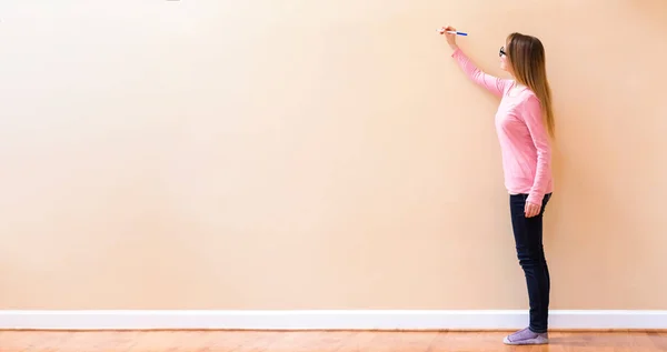 Young woman drawing on a big open wall — Stock Photo, Image