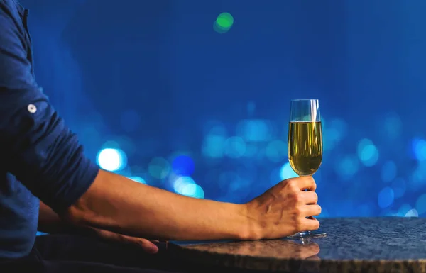 Muž s vínem vysoko nad městem v noci — Stock fotografie