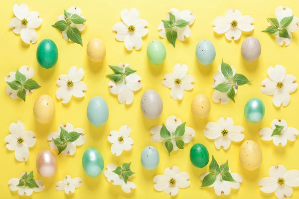 Fiori primaverili e uova pasquali su sfondo giallo — Foto Stock