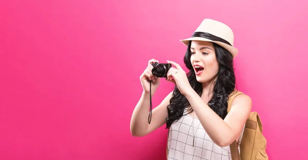 Traveling young woman holding a camera — Stock Photo, Image