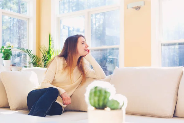 Ung kvinna avkopplande på en soffa — Stockfoto