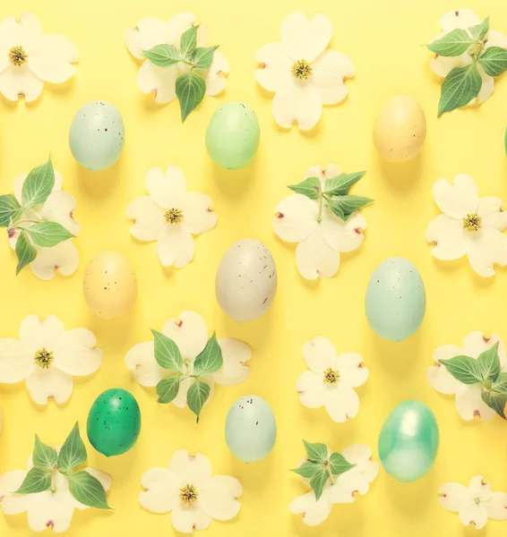 Fiori primaverili e uova pasquali su sfondo giallo — Foto Stock