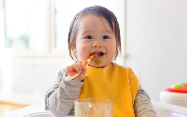 Happy little baby boy eating food — Stock Photo, Image